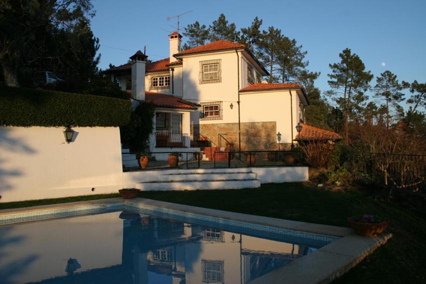 a house with a swimming pool in front of it at Quinta de Santa Maria do Dao in Santa Comba Dão