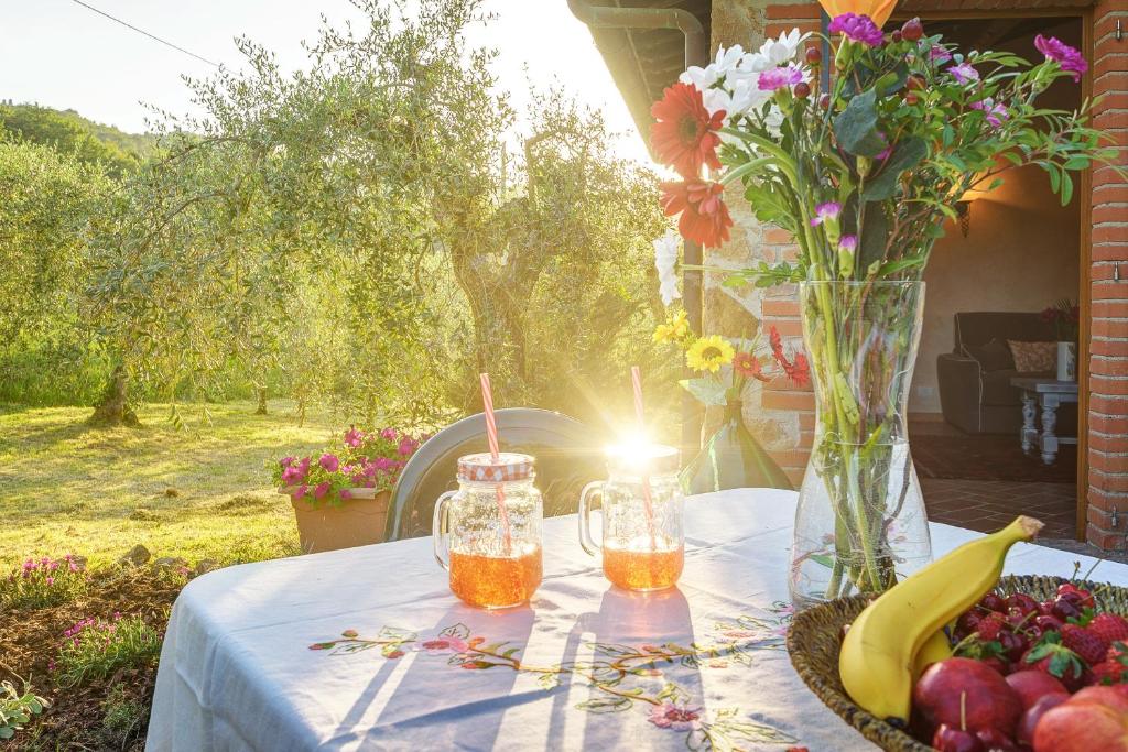una mesa con un bol de fruta y un jarrón de flores en Tuscan Roots, en La Croce