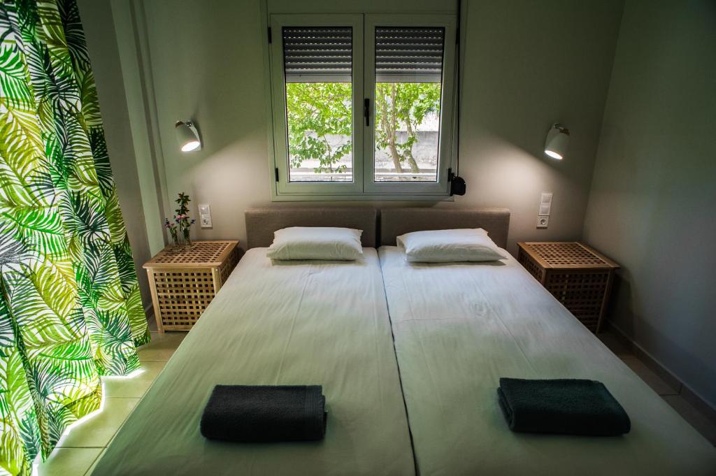 a large bed in a room with two windows at Aggeliki-Smaro Studios in Neos Pirgos