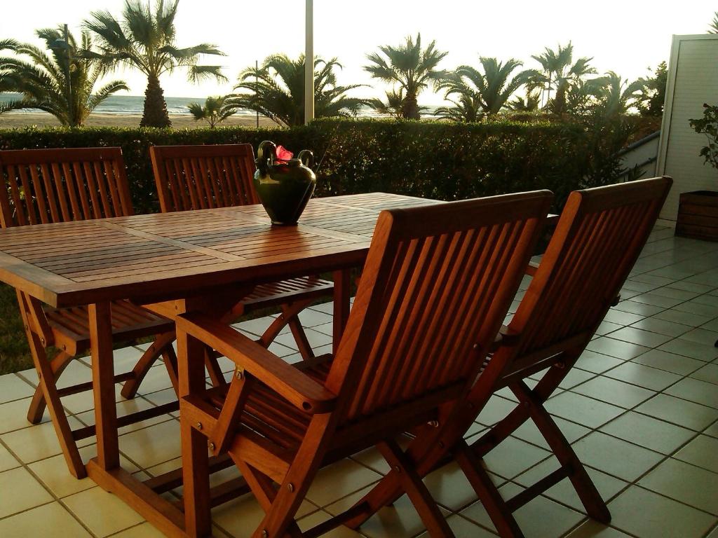 uma mesa e cadeiras de madeira com um vaso em Playa y Sol em Cubelles