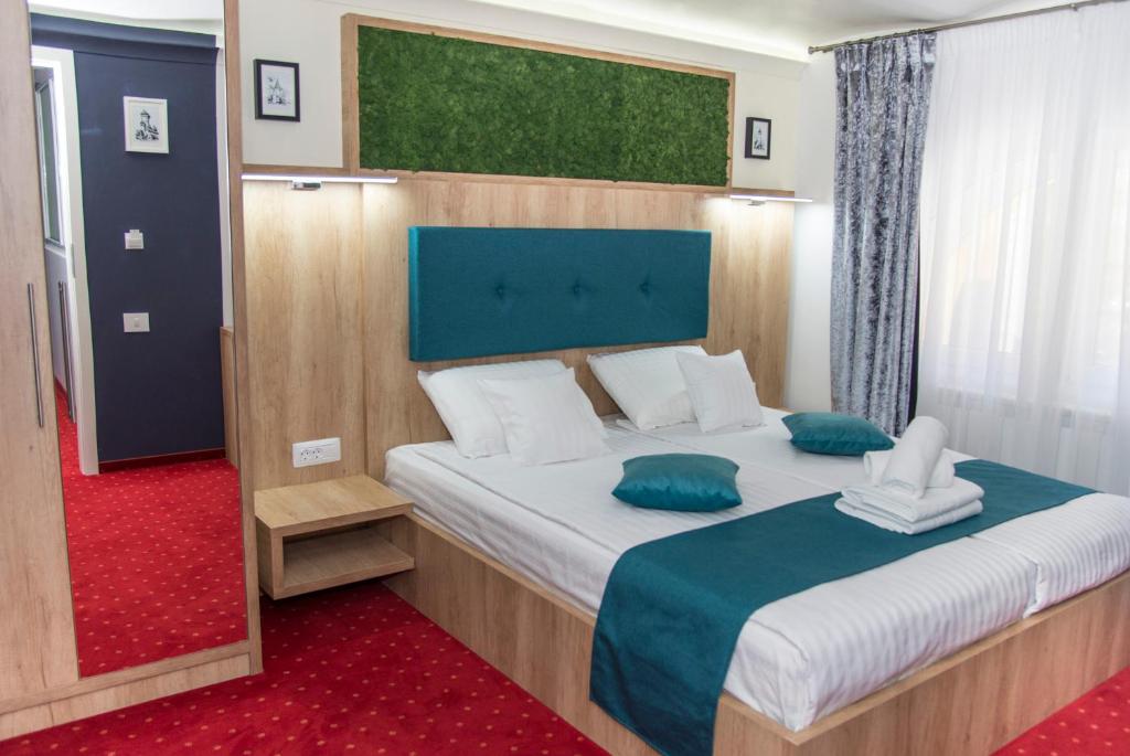 Un dormitorio con una cama grande con almohadas azules y blancas. en Brekner Rooms, en Sibiu