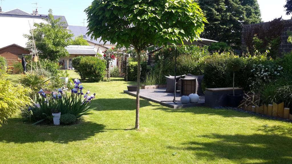 un jardín con un árbol en la hierba en Louane, en Le Mans