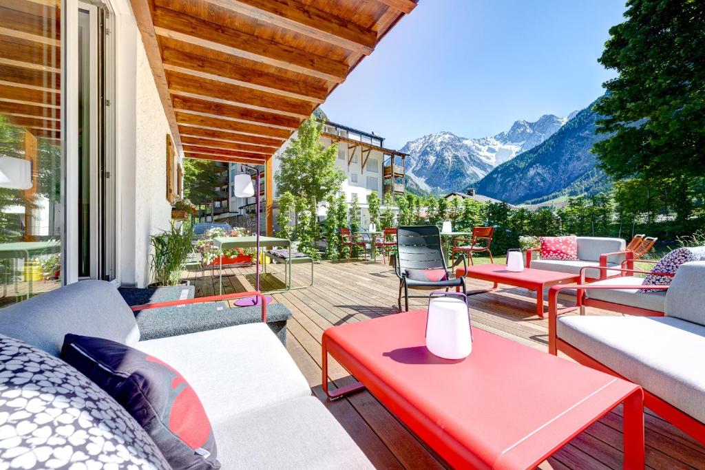 a patio with tables and chairs and mountains in the background at Hotel Lün in Brand