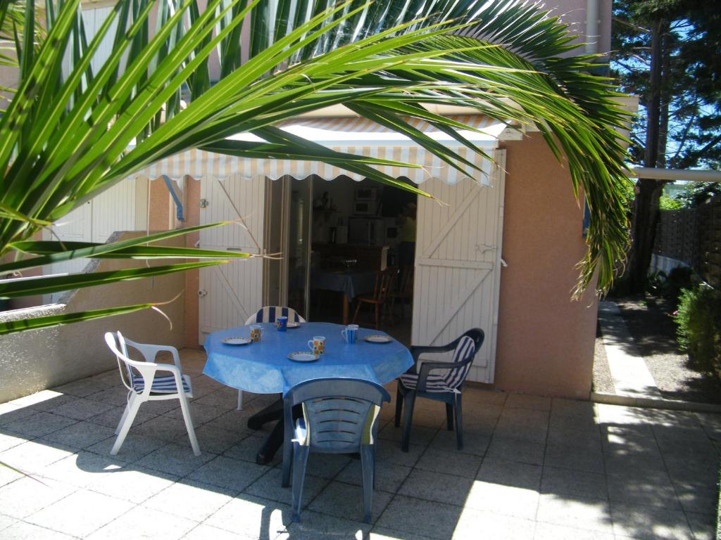 une table et des chaises bleues sur une terrasse dans l'établissement Villa T3, 4 personnes, Le Clos du Soleil, à Narbonne-Plage