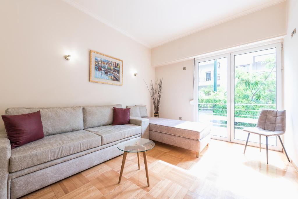 ein Wohnzimmer mit einem Sofa und einem Tisch in der Unterkunft Victoria Familia Apartments in Athen