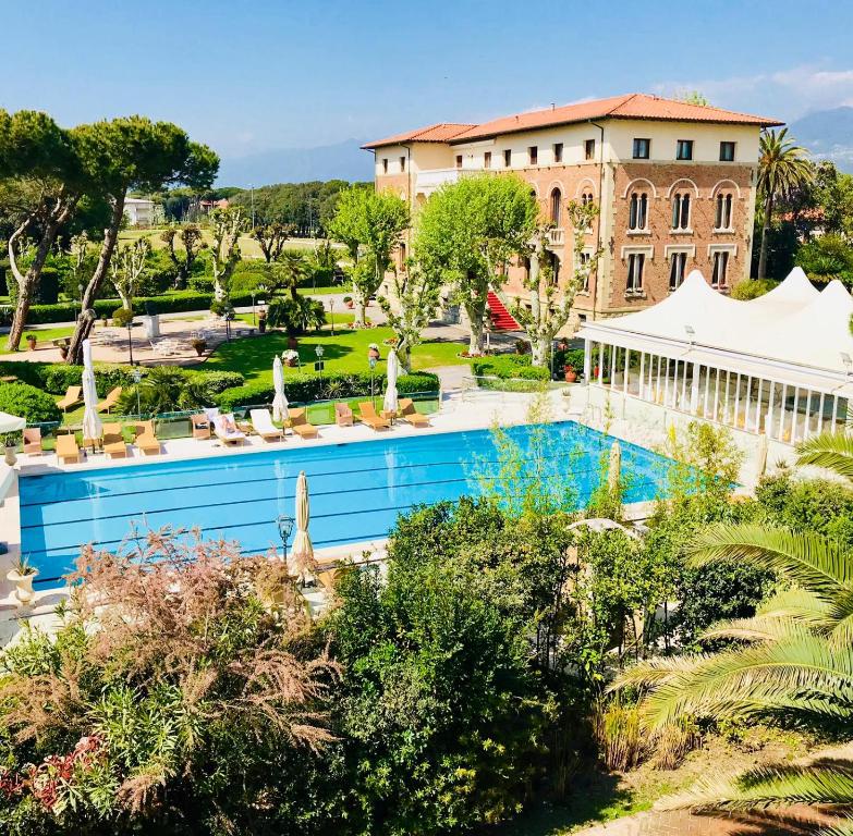 ein Resort mit einem Pool und einem Gebäude in der Unterkunft Park Hotel Villa Ariston in Lido di Camaiore