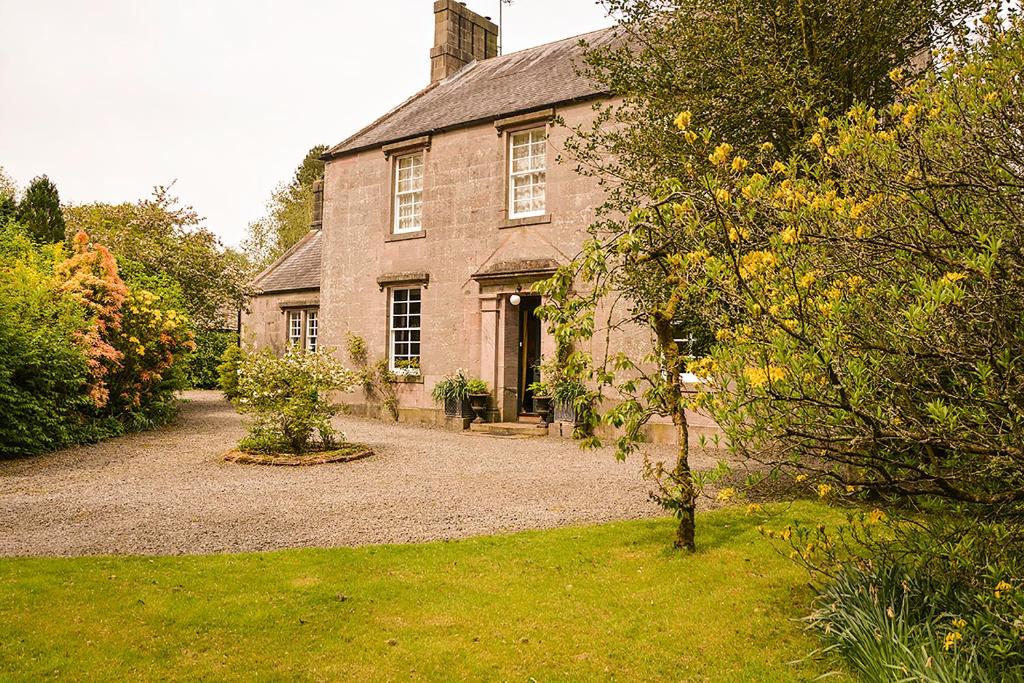 an old brick house with a yard in front of it at Scaurbridge House in Thornhill