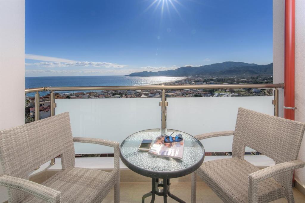 un tavolo e sedie su un balcone con vista sull'oceano di Das Maistrali 2 a Sárti