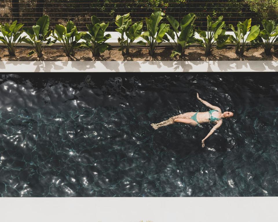 a person swimming in a pool of water at Alta House Begur in Begur