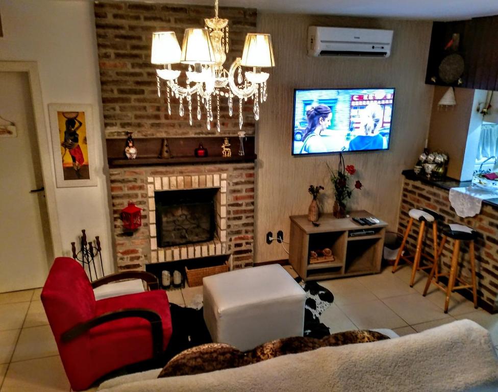 sala de estar con chimenea y TV en Chalé Vale do Bosque, en Gramado