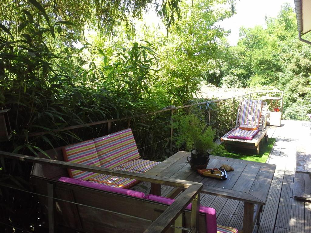 eine Terrasse mit 2 Stühlen und einem Tisch auf einer Terrasse in der Unterkunft Les Gites du Belvedere - Arbois in Arbois