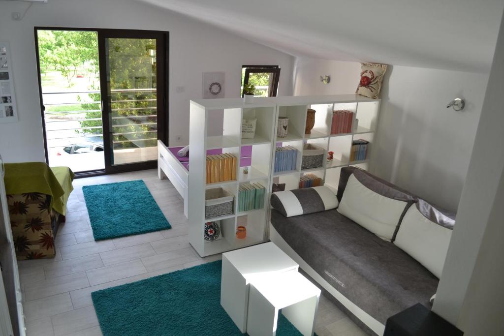 a living room with a couch and a book shelf at Apartments Niković in Risan