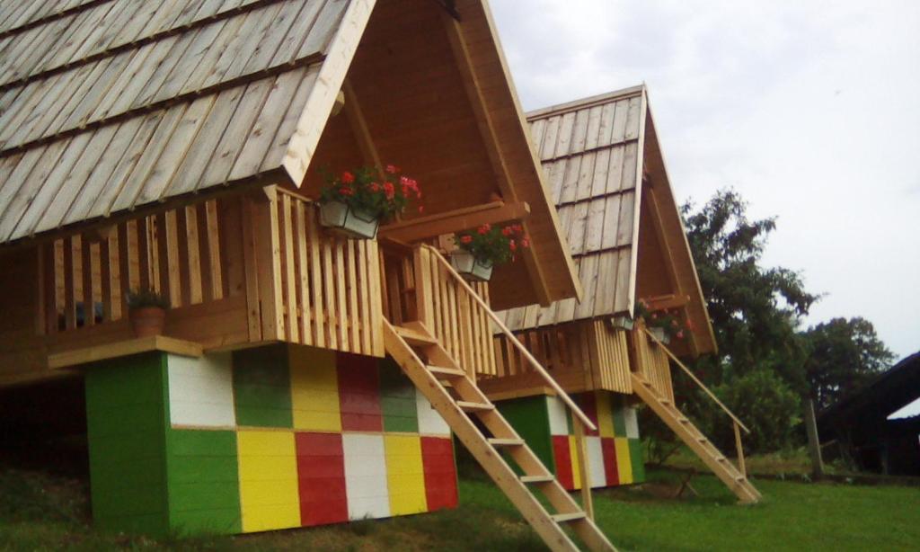 uma casa de brincar com uma escada e flores nela em farmglamping Planika - Encijan em Hraše