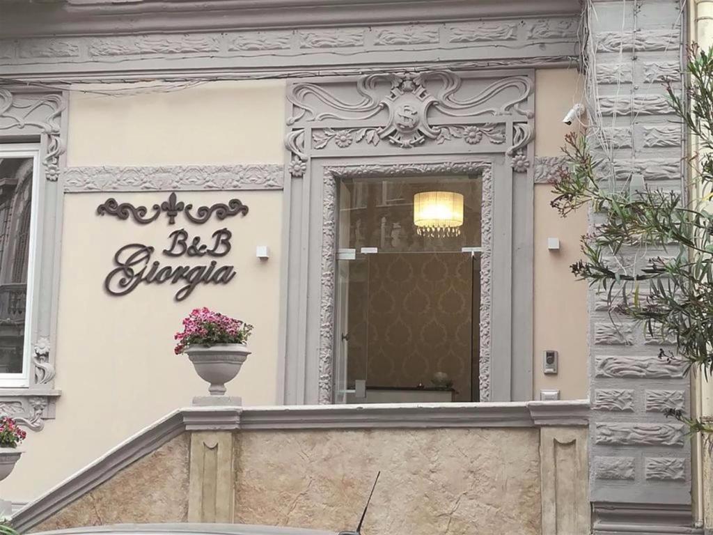 a sign on the side of a building with a flower pot at b&b Giorgia in Tropea