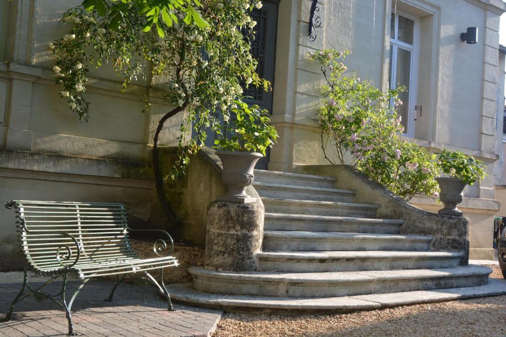 un conjunto de escaleras delante de un edificio con un banco en Villa Vesone en Périgueux