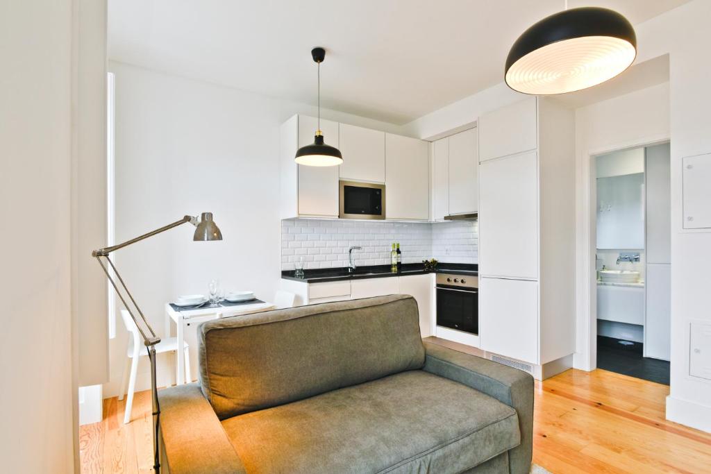 een woonkamer met een bank en een keuken bij BmyGuest - Arroios Cosy Apartment in Lissabon