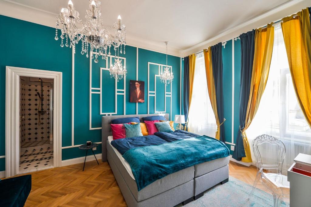プラハにあるGlamour Frida apartmentのベッドルーム1室(青い壁のベッド1台、シャンデリア付)
