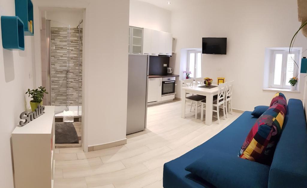 uma sala de estar com um sofá azul e uma cozinha em Nata em Korčula