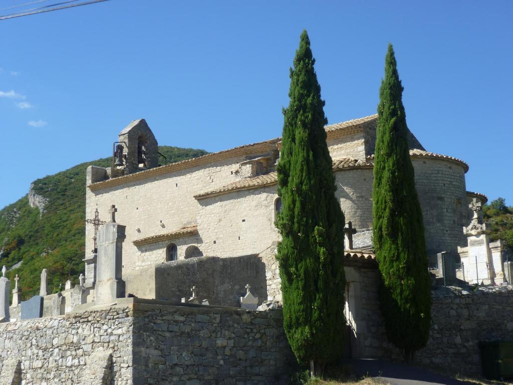 a building with two trees in front of it at Les Hirondelles in Pont-de-Barret