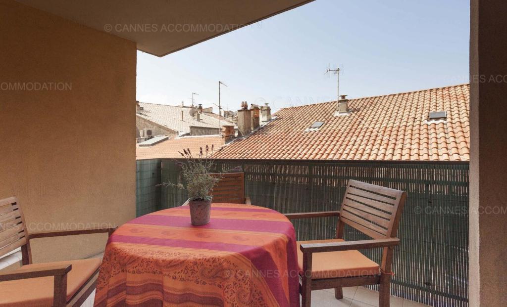 d'une table avec des chaises et un vase sur le balcon. dans l'établissement Lemoine, à Cannes