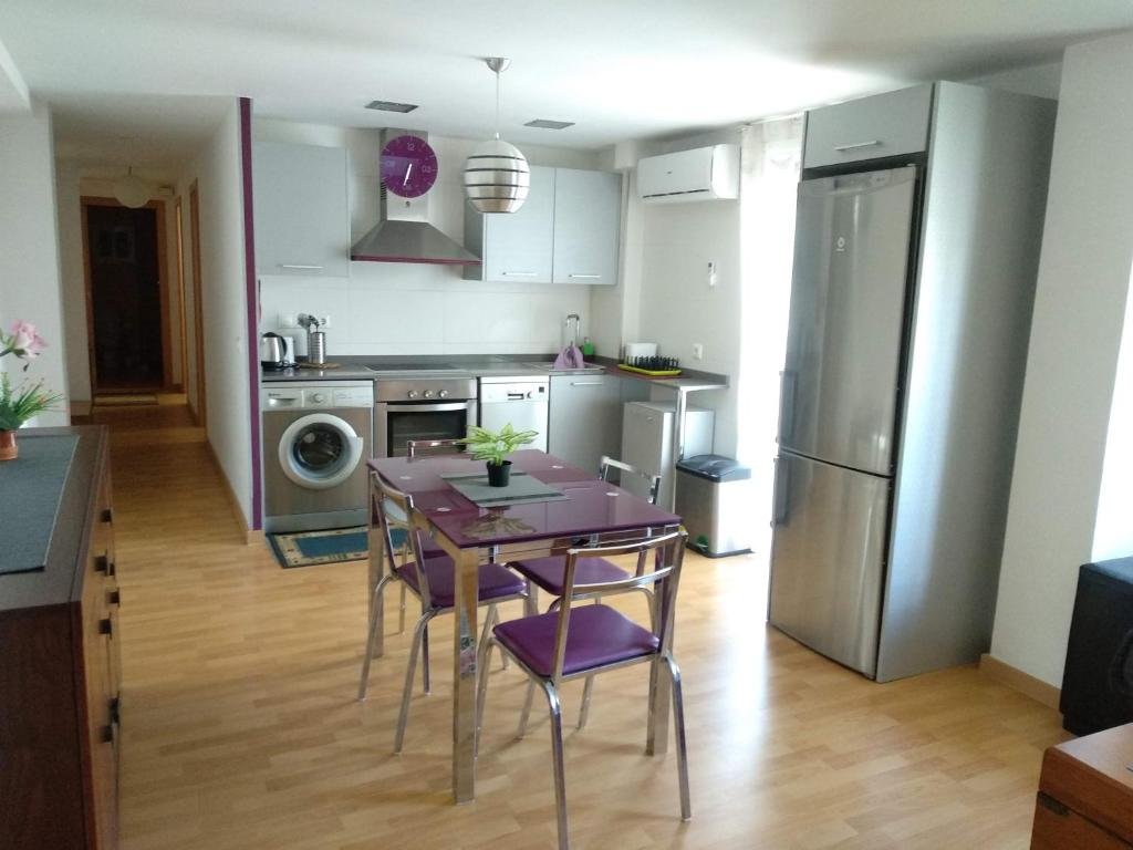 uma cozinha com uma mesa com cadeiras roxas em Apartamento en la Ciudad de las Artes y las Ciencias em Valência
