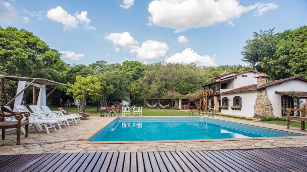a backyard with a swimming pool and a house at Pousada da Neneza in Santa Cruz de Minas