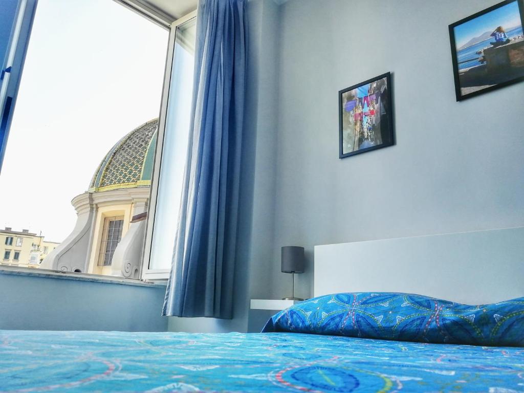 una camera con un letto e una grande finestra di Casa Sannì a Napoli