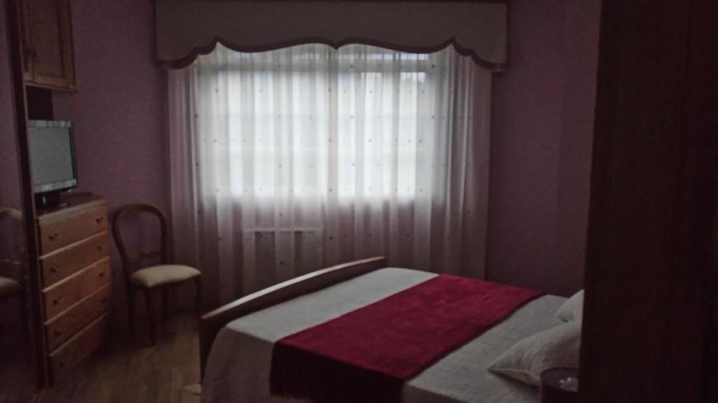 カマリーニャスにあるCasa Maricarmenのベッドルーム1室(窓、ベッド1台、椅子付)