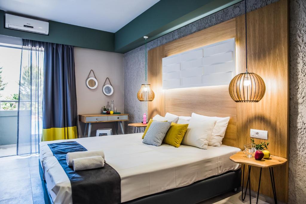 ein Schlafzimmer mit einem großen Bett und einem Fenster in der Unterkunft Sunshine Boutique Hotel in Malia