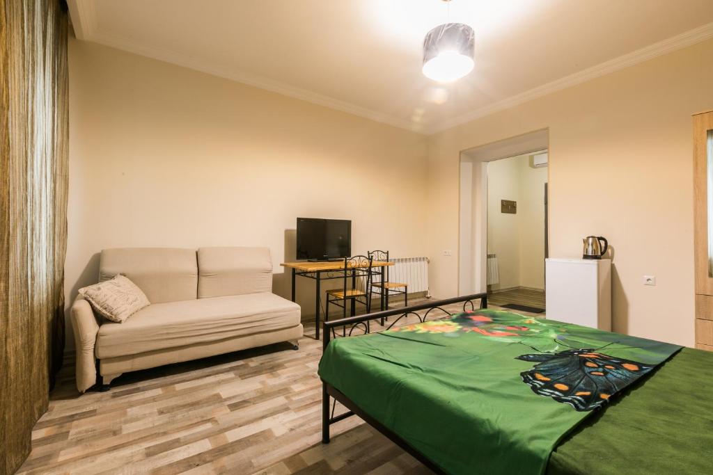 sala de estar con cama y sofá en New Life Apartments en Tiflis