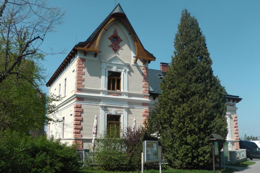 ein großes weißes Haus mit einem Turm darüber in der Unterkunft Penzion Vila Machů in Kopřivnice