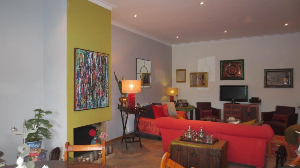 a living room with a red couch and a tv at A Casa do Lagar in Azeitao