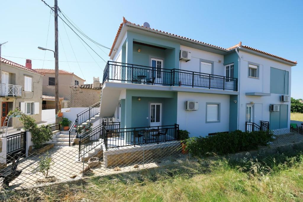 a house with a balcony on the side of it at Fergani Apartments in Moúdhros