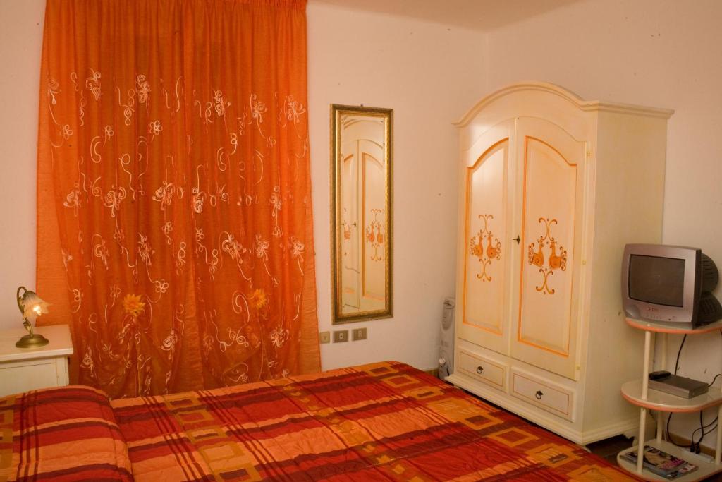 sypialnia z łóżkiem i telewizorem w obiekcie B&B Vecchia Alghero w mieście Alghero