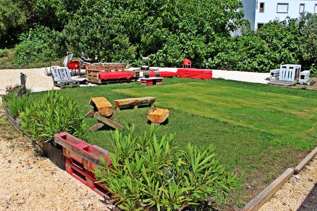 un jardin avec des tables et des chaises sur la pelouse dans l'établissement Horta do Vale - Nature House, à Odeceixe