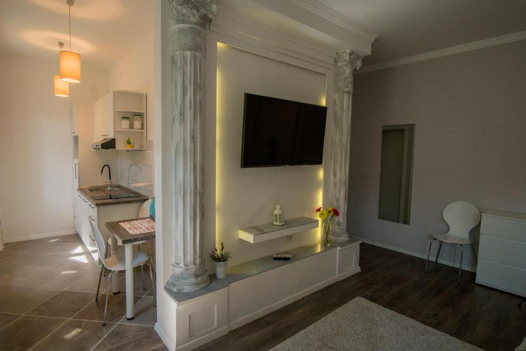 uma sala de estar com uma mesa e uma televisão na parede em JR Luxury Guesthouse em Split