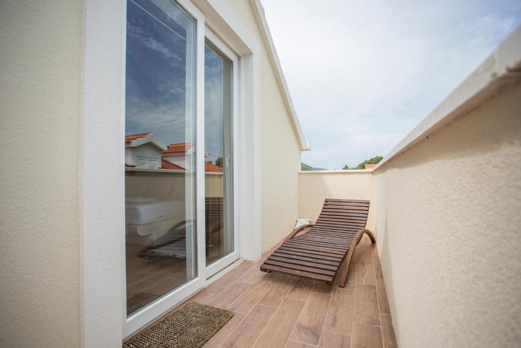 a balcony with a bench and a large window at Captain's Attic in Račišće