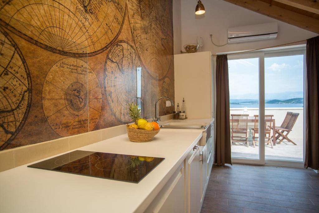 a kitchen with a counter with a bowl of fruit on it at Captain's Attic in Račišće