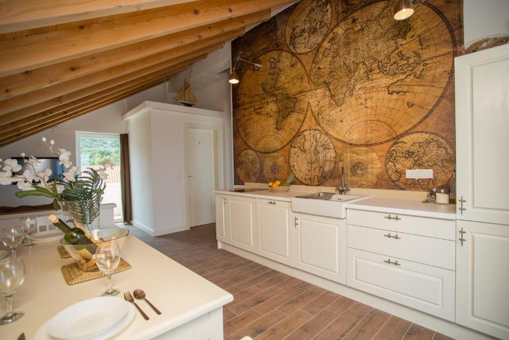 una cocina con armarios blancos y un mapa en la pared en Captain's Attic, en Račišće