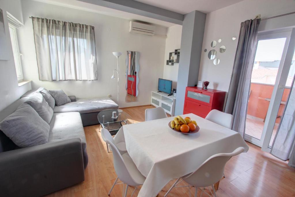 uma sala de estar com uma mesa e um sofá em Apartman Pula em Pula