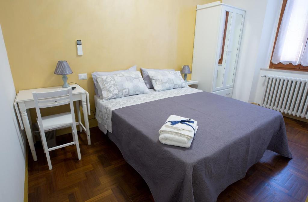 1 dormitorio con 1 cama y 1 mesa con silla en Marlin b&b, en San Benedetto del Tronto