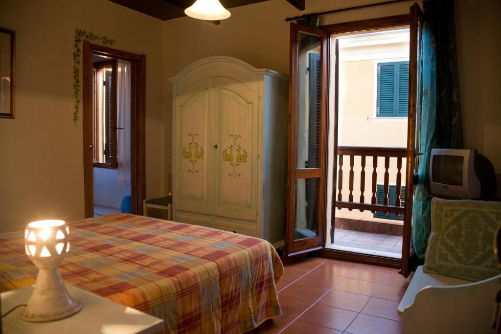 sypialnia z łóżkiem oraz balkon z telewizorem w obiekcie B&B Vecchia Alghero w mieście Alghero