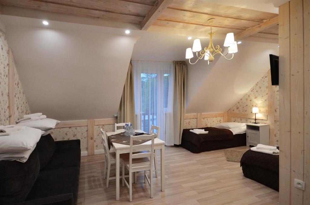 een woonkamer met 2 bedden en een tafel en stoelen bij Okrągłe Resort SKI & SAFARI in Orzysz