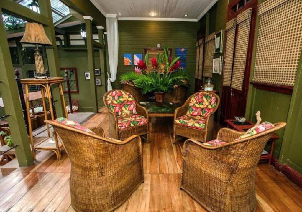 a living room with wicker chairs and a table at Hotel Aranjuez in San José