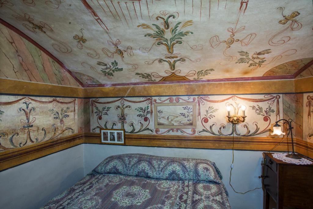 スポレートにあるLa Dimora Di Andromedaの天井画のあるベッドルーム1室、ベッド1台が備わります。