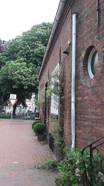 a brick building with a sign on the side of it at Haus am Hafen in Leer