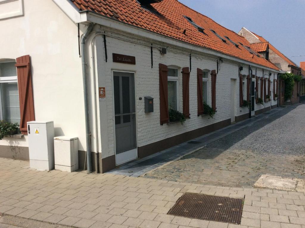 un edificio blanco con ventanas en una calle en Ter Ename n°1, en Ename