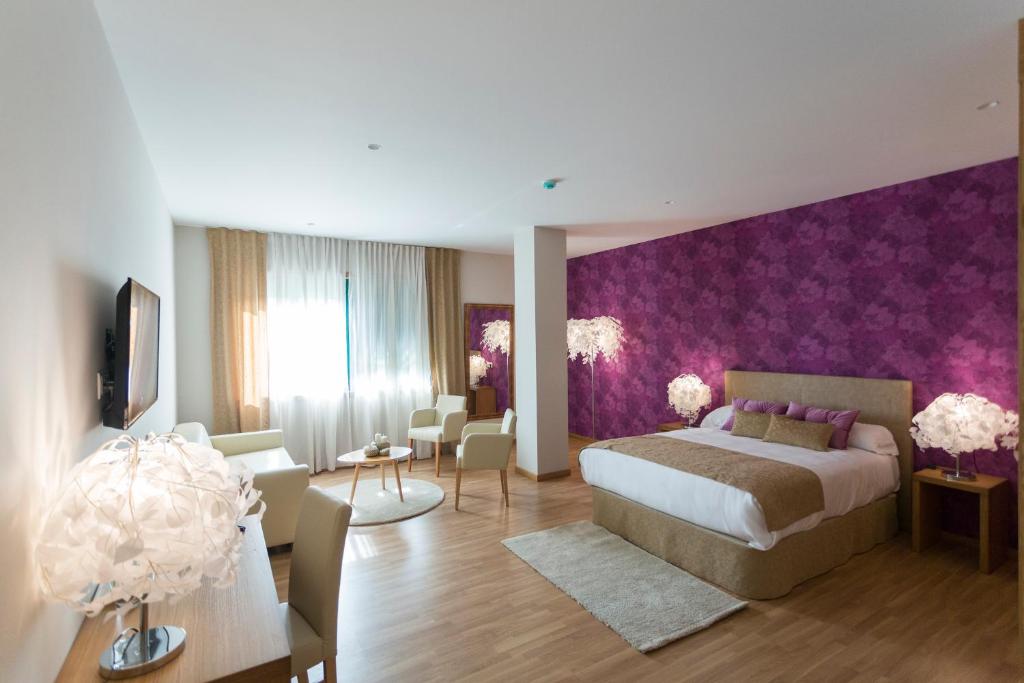 a bedroom with a bed and a purple wall at Hotel A Roldana in Narón