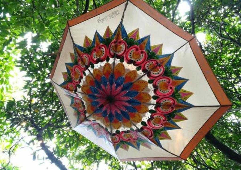 a colorful umbrella is hanging from a tree at Hotel Aranjuez in San José
