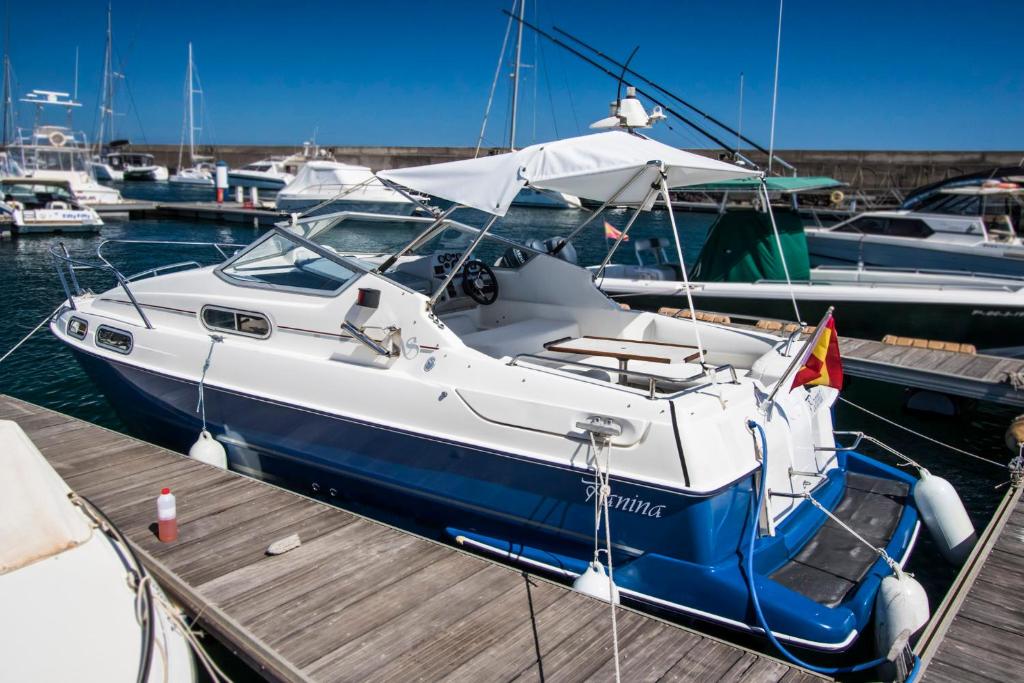 un barco atracado en un muelle con otros barcos en Cozy boat to unwind by the ocean en Puerto Calero